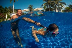Father and daughter playing in a swimming pool Stock Photography Father and daughter playing in a swimming pool Stock Photography