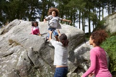 Father Helping Children To Jump Off Rocks royalty free stock images Father Helping Children To Jump Off Rocks royalty free stock images