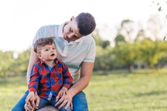 Father and his son having fun outside in summer hugging and laughing. Father taking care of his child stock photo Father and his son having fun outside in summer hugging and laughing. Father taking care of his child stock photo