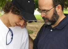 Father and Son. Teenage boy and mature man having a conversation in an outdoor setting Father and Son. Teenage boy and mature man having a conversation in an outdoor setting
