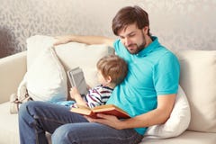 Father and son read a book or tablet stock photo Father and son read a book or tablet stock photo