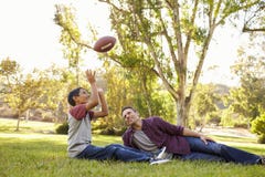 Father and son relax, throwing American football in a park stock images Father and son relax, throwing American football in a park stock images