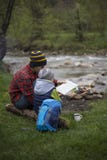 Father and son sitting near a campfire at the campsite and are l royalty free stock photo Father and son sitting near a campfire at the campsite and are l royalty free stock photo