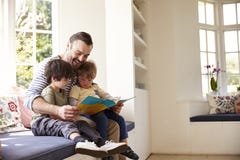 Father And Sons Reading Story At Home Together stock image Father And Sons Reading Story At Home Together stock image