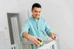 Father with tablet pc and ruler measuring baby bed royalty free stock images Father with tablet pc and ruler measuring baby bed royalty free stock images