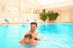 Father teaching son to swim with inflatable sleeve royalty free stock photos Father teaching son to swim with inflatable sleeve royalty free stock photos