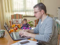 Father working in home office and son playing stock photo Father working in home office and son playing stock photo
