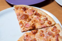 Fatia quente da pizza com queijo de derretimento em uma tabela rústica foto de stock Fatia quente da pizza com queijo de derretimento em uma tabela rústica foto de stock