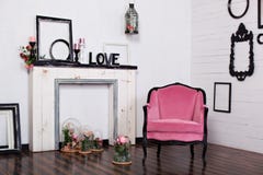 Fauteuil de velor de cru, dans une salle lumineuse et une chemin?e artificielle Grenier int?rieur avec les murs blancs en bois Ca photographie stock libre de droits Fauteuil de velor de cru, dans une salle lumineuse et une chemin?e artificielle Grenier int?rieur avec les murs blancs en bois Ca photographie stock libre de droits