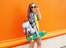 Façonnez à hippie de sourire heureux la fille fraîche dans des lunettes de soleil avec le patin photographie stock libre de droits Façonnez à hippie de sourire heureux la fille fraîche dans des lunettes de soleil avec le patin photographie stock libre de droits