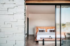 White contemporary hotel style bedroom with gray color stone wall exterior decoration royalty free stock photography White contemporary hotel style bedroom with gray color stone wall exterior decoration royalty free stock photography