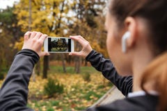 Feche acima da mulher da aptidão nos fones de ouvido que tomam uma foto foto de stock Feche acima da mulher da aptidão nos fones de ouvido que tomam uma foto foto de stock