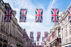 Feche acima das construções em Regent Street London com fileira de bandeiras britânicas para comemorar o casamento do príncipe Ha imagens de stock Feche acima das construções em Regent Street London com fileira de bandeiras britânicas para comemorar o casamento do príncipe Ha imagens de stock
