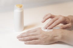 Feche acima das mãos de uma mulher que tome dsi mesma friccionando o creme com os dois dedos na parte de trás de sua mão esquerda imagens de stock royalty free Feche acima das mãos de uma mulher que tome dsi mesma friccionando o creme com os dois dedos na parte de trás de sua mão esquerda imagens de stock royalty free
