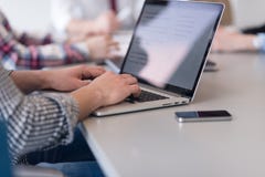 Feche acima das mãos do homem de negócio que datilografam no portátil com a equipe no mee imagem de stock royalty free Feche acima das mãos do homem de negócio que datilografam no portátil com a equipe no mee imagem de stock royalty free