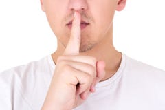 Feche acima do homem com o dedo nos bordos que pede o silêncio sobre o whit fotos de stock Feche acima do homem com o dedo nos bordos que pede o silêncio sobre o whit fotos de stock