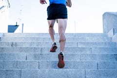 Feche acima do homem novo que corre acima as escadas com roupa running foto de stock Feche acima do homem novo que corre acima as escadas com roupa running foto de stock