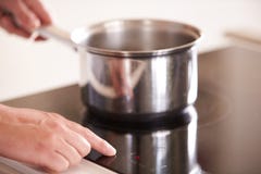 Feche acima do homem que seleciona a temperatura no Hob do fogão imagens de stock Feche acima do homem que seleciona a temperatura no Hob do fogão imagens de stock
