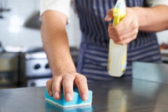 Feche acima do trabalhador na cozinha do restaurante que limpa para baixo após Ser fotografia de stock Feche acima do trabalhador na cozinha do restaurante que limpa para baixo após Ser fotografia de stock