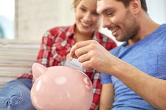 Feche acima dos pares com o mealheiro que senta-se no sofá imagem de stock Feche acima dos pares com o mealheiro que senta-se no sofá imagem de stock