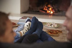 Feche acima dos pés como a família relaxa ao lado do fogo aberto imagem de stock Feche acima dos pés como a família relaxa ao lado do fogo aberto imagem de stock