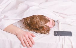 Feche acima dos pés em uma cama sob a cobertura branca Imagem que mostra o homem novo que estica na cama Relaxamento na manhã imagem de stock royalty free Feche acima dos pés em uma cama sob a cobertura branca Imagem que mostra o homem novo que estica na cama Relaxamento na manhã imagem de stock royalty free