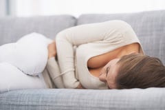 Feeling bad young woman laying on sofa stock image Feeling bad young woman laying on sofa stock image