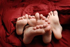 Feet in Bed with Red Blanket Resting stock image Feet in Bed with Red Blanket Resting stock image
