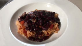 Feijão vermelho e salsicha que estão sendo ladled sobre o arroz espanhol vídeos de arquivo Feijão vermelho e salsicha que estão sendo ladled sobre o arroz espanhol vídeos de arquivo