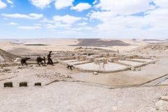 Feito de silhuetas do metal de um homem com asnos e um cão e da adega nas ruínas da cidade Avdat de Nabataean, no deserto de Jude imagens de stock royalty free Feito de silhuetas do metal de um homem com asnos e um cão e da adega nas ruínas da cidade Avdat de Nabataean, no deserto de Jude imagens de stock royalty free