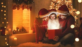 Feliz Natal! pai e criança felizes da mãe da família com mágica imagens de stock Feliz Natal! pai e criança felizes da mãe da família com mágica imagens de stock