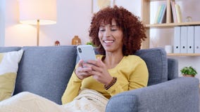 Jovem mulher sorrindo e rindo enquanto envia mensagens de texto em um  telefone em casa mulher alegre conversando com seus amigos com aplicativos  rolando mídias sociais e assistindo memes engraçados da internet enquanto  relaxa em um sofá