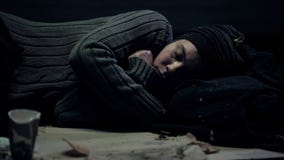 Female bum sleeping on dirty street feeling cold, poverty problem, refugee stock images Female bum sleeping on dirty street feeling cold, poverty problem, refugee stock images