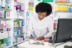 Female Chemist Writing On Clipboard At Counter stock images Female Chemist Writing On Clipboard At Counter stock images