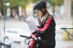 Female Cyclist Putting Package In Courier Bag Stock Photo Female Cyclist Putting Package In Courier Bag Stock Photo