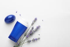 Female deodorant and lavender flowers on white background