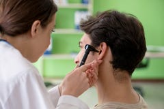 The female doctor checking patient`s ear during medical examination stock photo The female doctor checking patient`s ear during medical examination stock photo