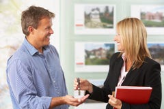 Female Estate Handing Over Keys Of New Home stock image Female Estate Handing Over Keys Of New Home stock image