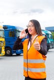 Female forwarder in front of trucks on a depot stock photos Female forwarder in front of trucks on a depot stock photos