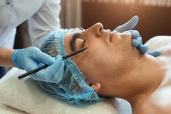 Female gands in gloves marking man face stock image Female gands in gloves marking man face stock image