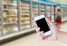 Female hand holding mobile smart phone on Supermarket royalty free stock photos Female hand holding mobile smart phone on Supermarket royalty free stock photos
