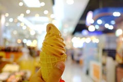 A female hand holding a soft cone of Thai tea ice cream stock photo A female hand holding a soft cone of Thai tea ice cream stock photo