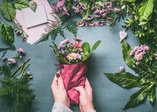 Female hand making beautiful bouquet of pink flowers on florist workspace, top view. Woman wrap bouquet in wrapping paper royalty free stock photography Female hand making beautiful bouquet of pink flowers on florist workspace, top view. Woman wrap bouquet in wrapping paper royalty free stock photography