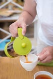 Female hands pouring tea into a Ñup stock photo Female hands pouring tea into a Ñup stock photo