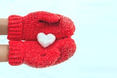 Female hands in warm red crocheted mittens with snowy heart. Whi royalty free stock images Female hands in warm red crocheted mittens with snowy heart. Whi royalty free stock images