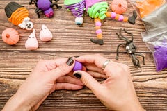 Female Hands With Black Nails Making Halloween Craft From Polymer Clay On Wooden Table Top View Royalty Free Stock Photography
