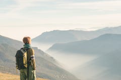Female hiker with backpack looking at the majestic view on the italian Alps. Mist and fog in the valley below, snowcapped mountain stock photos Female hiker with backpack looking at the majestic view on the italian Alps. Mist and fog in the valley below, snowcapped mountain stock photos