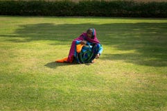 Female Indian mow hand lawn with green grass. Hard work of poor people in India. stock photo Female Indian mow hand lawn with green grass. Hard work of poor people in India. stock photo
