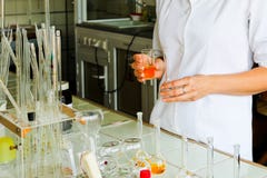 A female laboratory assistant, a doctor, a chemist, works with flasks, test tubes, makes solutions, medicines, mixes ingredients stock image A female laboratory assistant, a doctor, a chemist, works with flasks, test tubes, makes solutions, medicines, mixes ingredients stock image