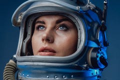Female modern cosmonaut in spacesuit and helmet